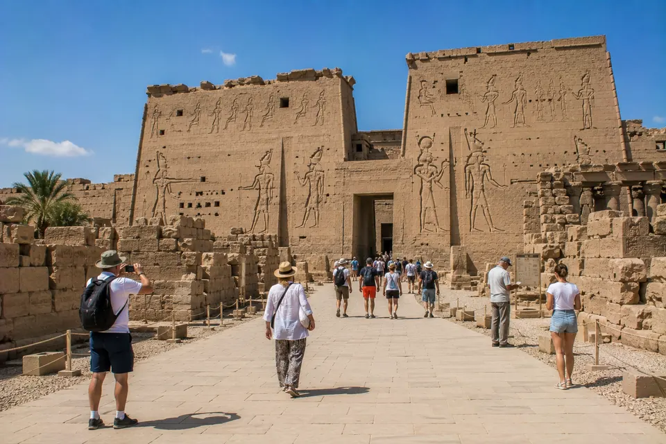 Tourists at the carved pylon of the Temple of Horus at Edfu