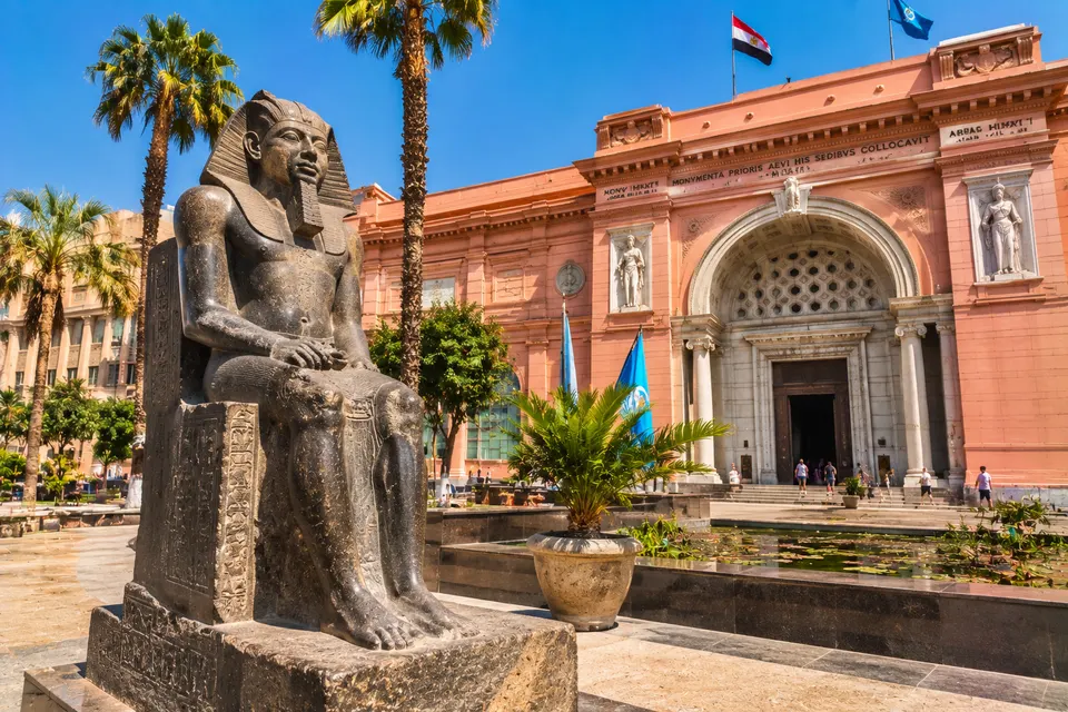Facade of the Egyptian Museum in Tahrir Square with a seated statue