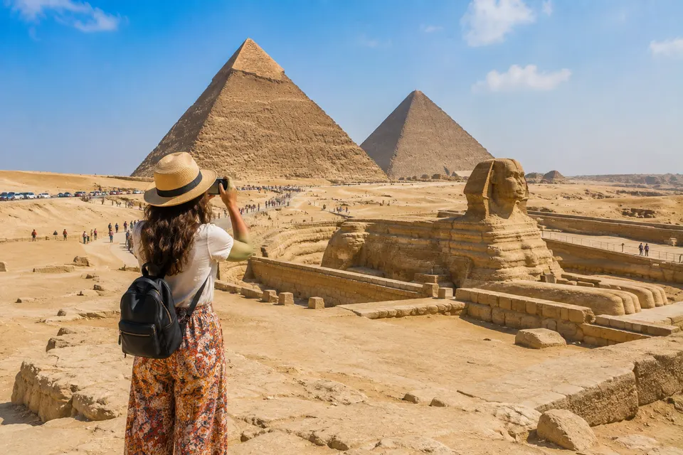 Woman photographing the Sphinx and the pyramids