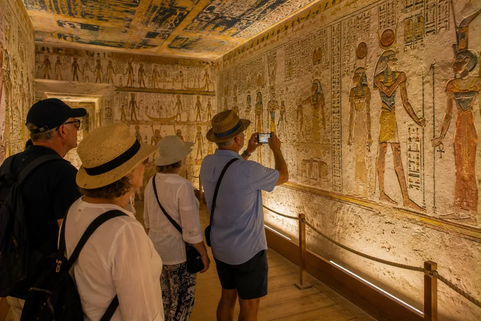 Tourists inside a painted royal tomb